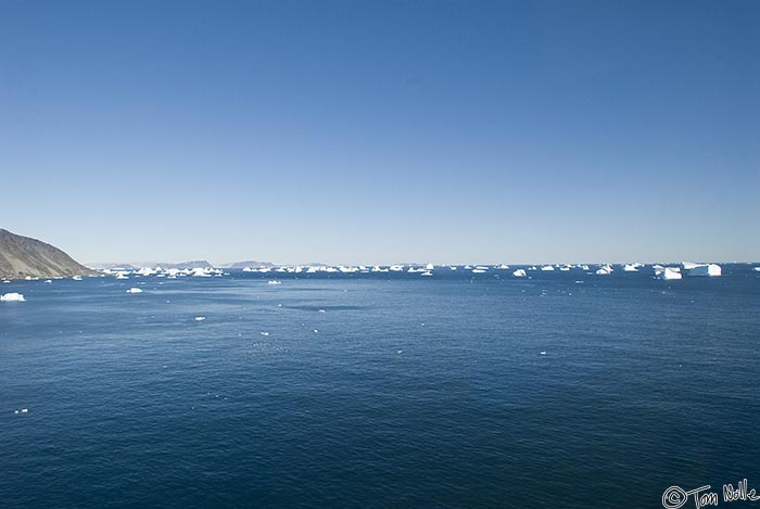 ArcticQ_20080829_143848_798_20.jpg - As we approach land, the icebergs moving out of the bay on the opposite side become clear.  Cape York, Nunavut, Canada.