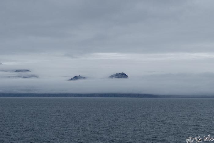 ArcticQ_20080905_115206_189_20.jpg - Mountains poke through a low layer of fog on the northern coast of Baffin Island, Nunavut, Canada.