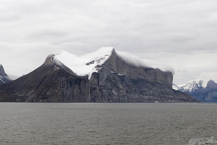 ArcticQ_20080906_090922_225_20.jpg - A cloud flows over the edge of the south side of Sam Ford Fjord Baffin Island, Nunavut, Canada.