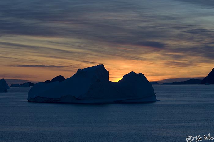 ArcticQ_20080829_213910_568_2X.jpg - A mid-sized iceberg is dark against the sunset.  Cape York, Nunavut, Canada.