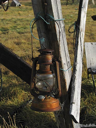 ArcticQ_20080830_084802_531_S.jpg - A rusty oil lamp hangs on a rail fence in the Inuit community of Qaanaaq,Greenland.